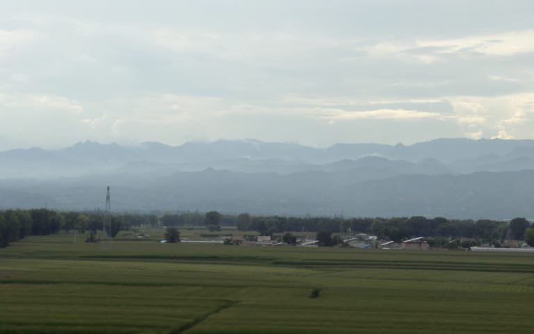途经南高村，开阔的农田延伸到远方，山脉在薄雾中若隐若现