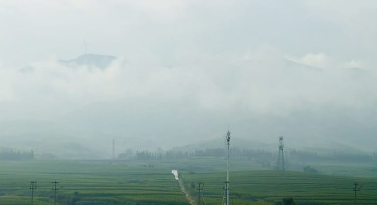 途经四岔尧村，山头从云海中探出，前景是农田与电线杆