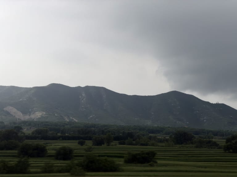 途经西兴庄村，远处的山脊在低云中若隐若现，前景是开阔的平原田野
