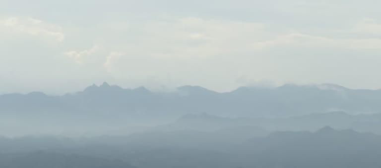 途经银山野区，多层山脊在雾气中层层叠叠，云雾贴着山脊轮廓
